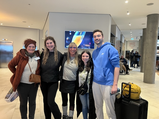       Group of five people posing in an indoor setting.
  