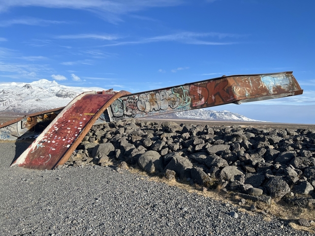       Rusty structure with graffiti in snow-covered landscape.
  