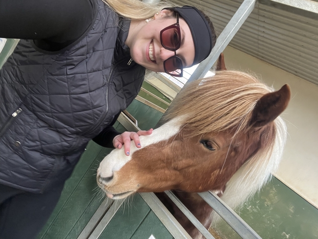       Person smiling with an Icelandic horse.
  