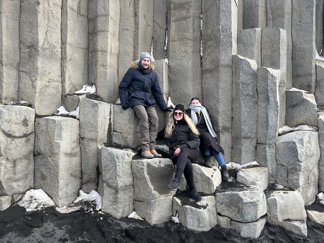       People sitting on basalt columns.
  