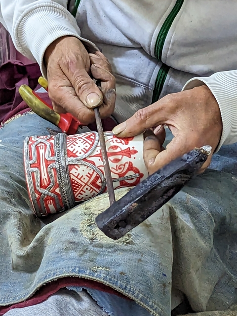       Artisan working on a decorative item.
  