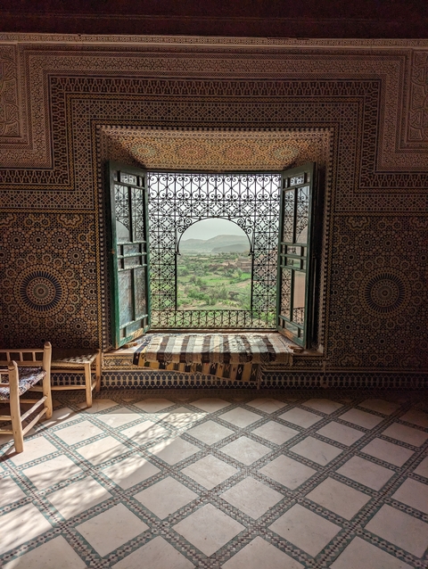       A beautifully decorated window with a view of a landscape outside.
  