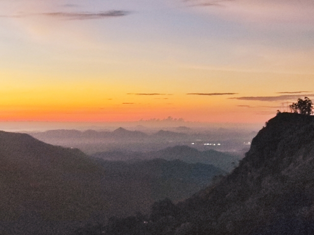       A sunrise view over a mountainous landscape.
  
