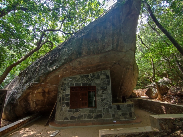       A large rock formation with a building built into it.
  