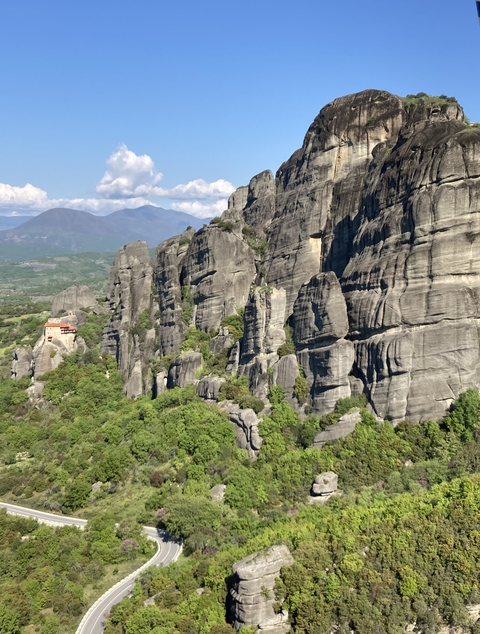 Dramatic rock formations in a lush green landscape.