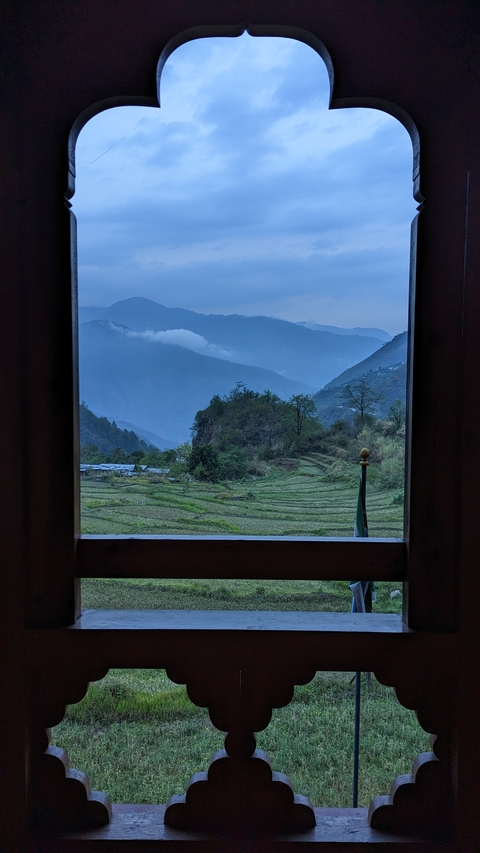       Serene mountainous landscape viewed through a window.
  