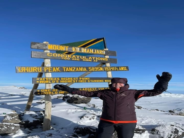 Successful climber at the summit of Mount Kilimanjaro.