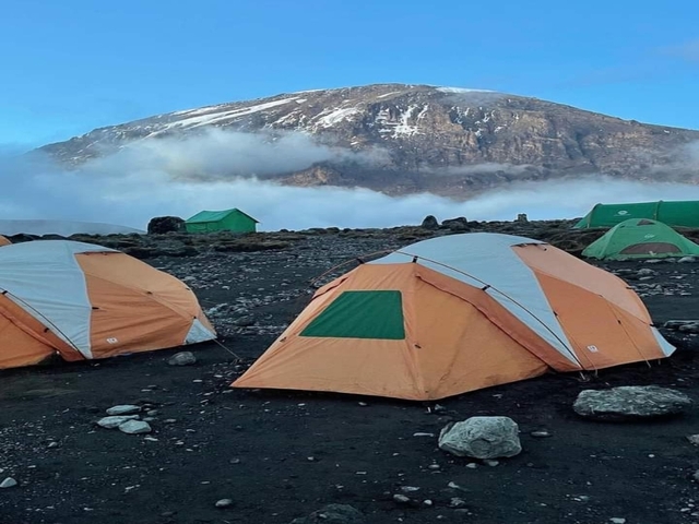 Campsite with tents and a mountain in the background.