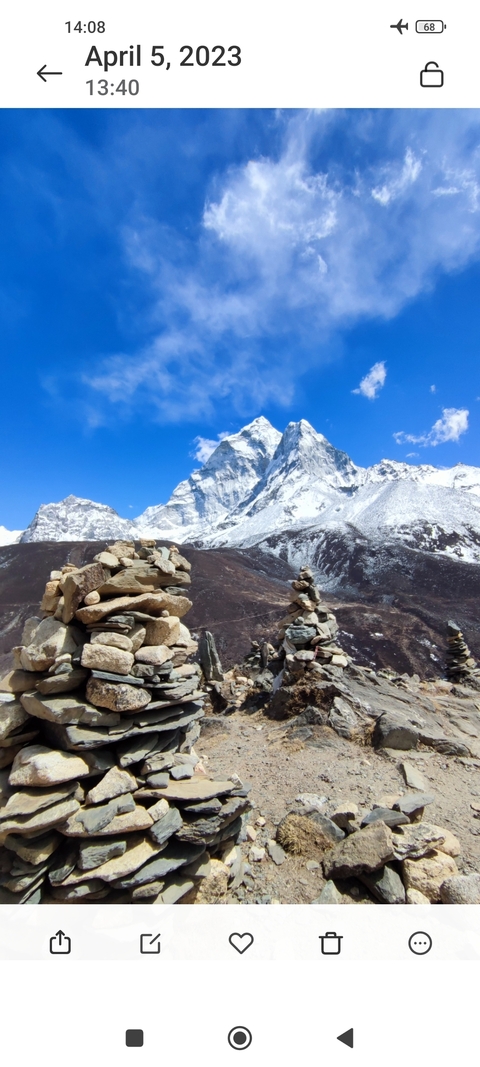 Stacked rocks with peak of a snowy mountain in the backdrop.