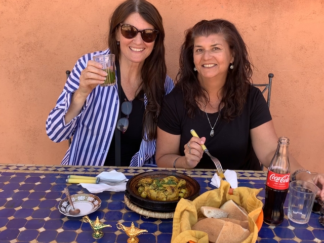       Two women enjoying a meal outdoors.
  