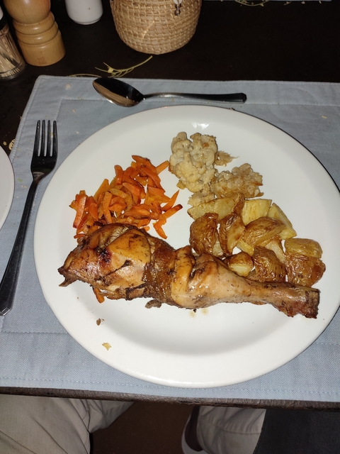       Plate with roasted chicken leg, carrots, potatoes, and cauliflower.
  