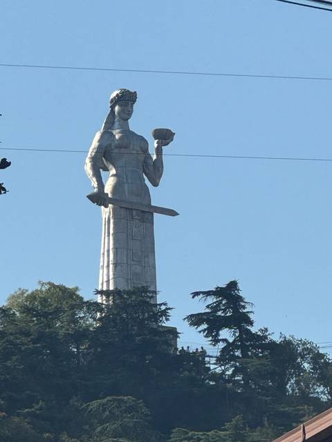       A statue holding a cup and a sword.
  
