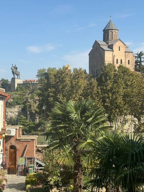       A church seen through lush trees.
  