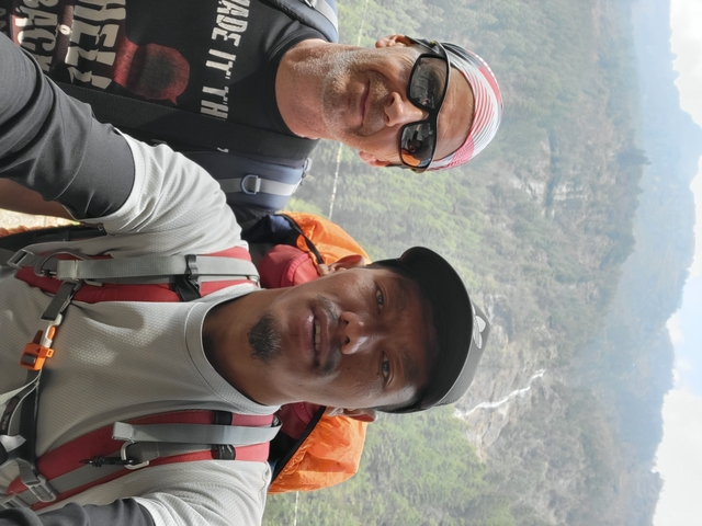 Two people with trekking gear in a mountainous area.