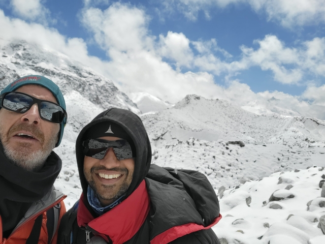 Two people in winter clothing in a snowy mountainous terrain.