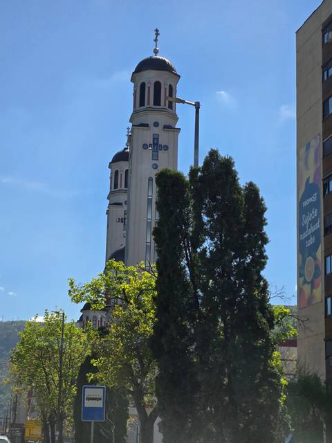 Tall church building with trees in the foreground.