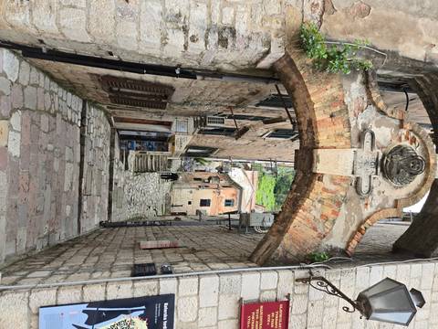 Narrow alley with stone arch and historical buildings.