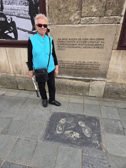       Person standing beside etched footmarks on pavement.
  