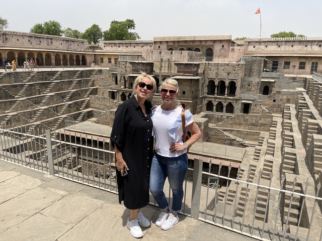       Two women posing at the Chand Baori stepwell in India.
  