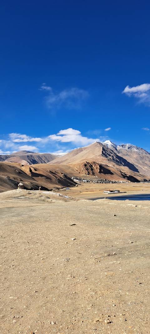 Sparse desert landscape with mountains and clear skies.