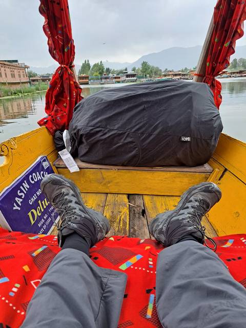 View of two people's feet over a decorated boat.