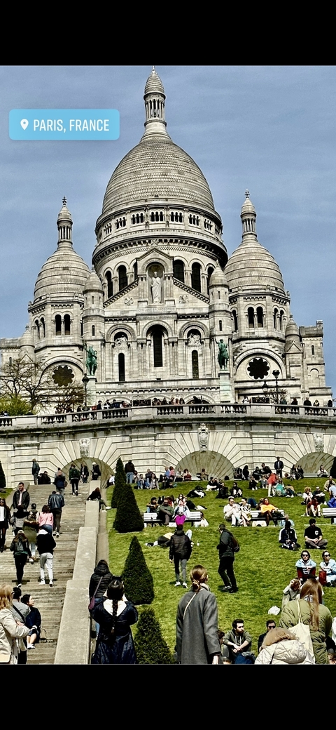 Close-up view of the Basilica of the Sacré-Cœur with people on the steps.