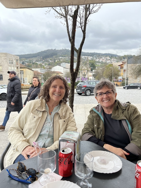       Two women sitting at an outdoor café in a Portuguese city.
  