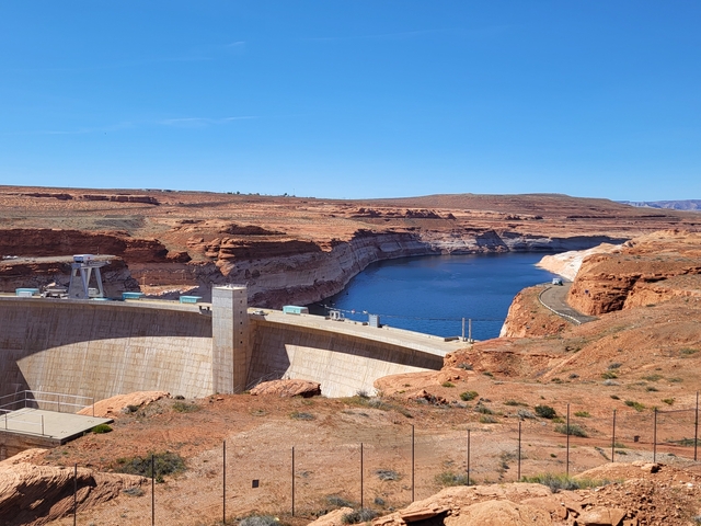View of a large dam and reservoir in a desert landscape.