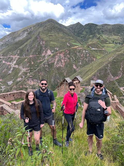 Group of hikers posing on a trail with a scenic backdrop.