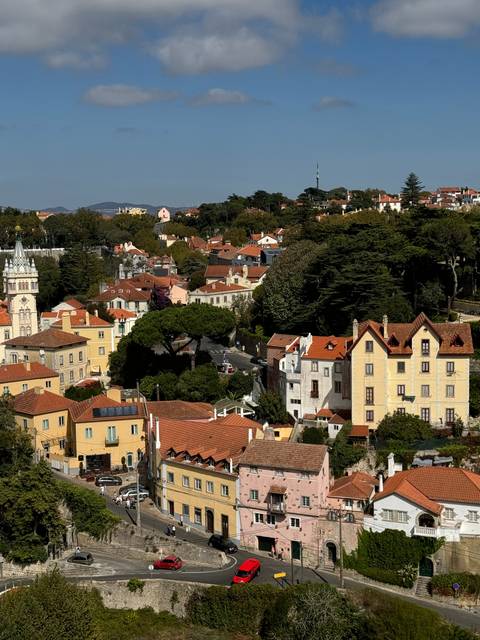 Cityscape with colorful buildings and red car.