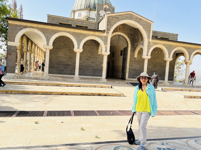       Person walking near a church with arches.
  