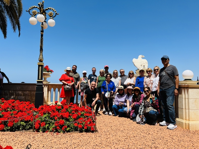 Group photo at viewpoint with red flowers in foreground.