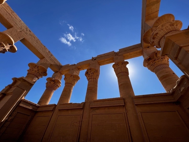       Ancient columns with carvings under the sun.
  