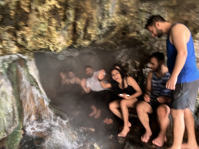       Group of people inside a misty cave-like area.
  