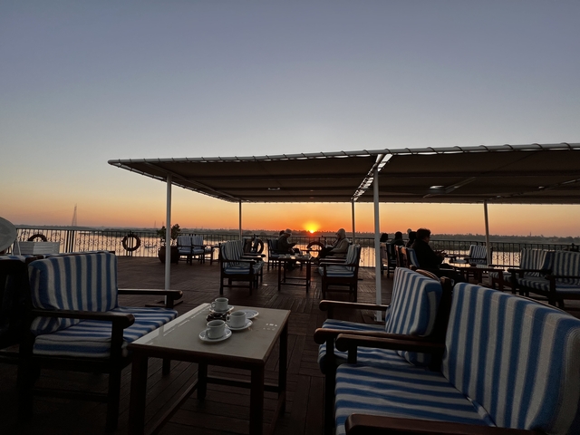       People enjoying a sunset on a cruise deck.
  