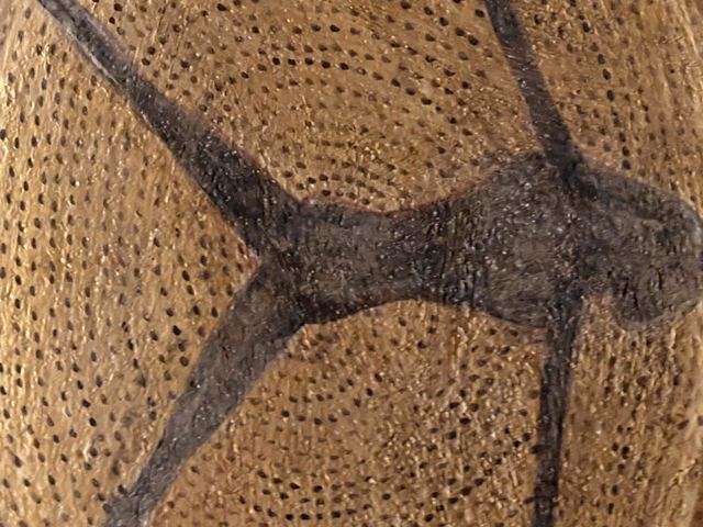       Close-up of a wooden sculpture or craft with carvings.
  