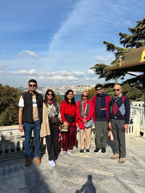 Group standing on a viewpoint overlooking a city.
