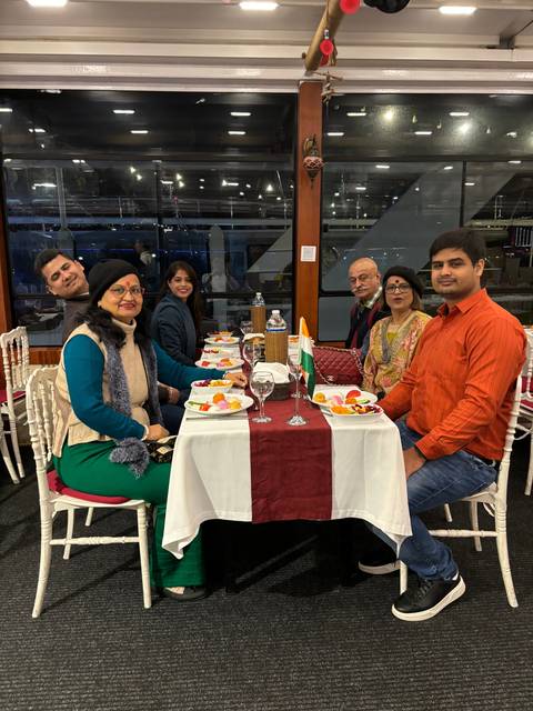 People sitting around a table having a meal on a boat.