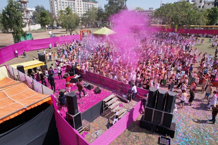       Festive crowd celebrating with pink color powder.
  