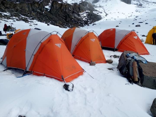       Orange tents in a snowy campsite.
  