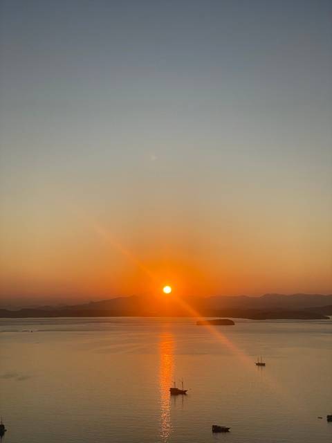 Sunset with a vivid sun reflecting on the water