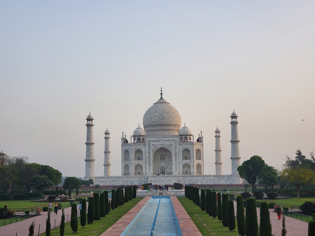       Taj Mahal with trees and a pathway leading to the entrance.
  