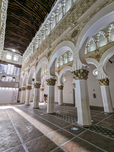       Traditional blue-painted alley with potted plants and decorative items.
  