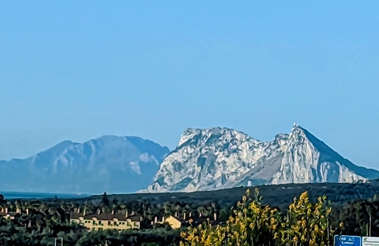       Seaside city view from a distance with clear skies.
  