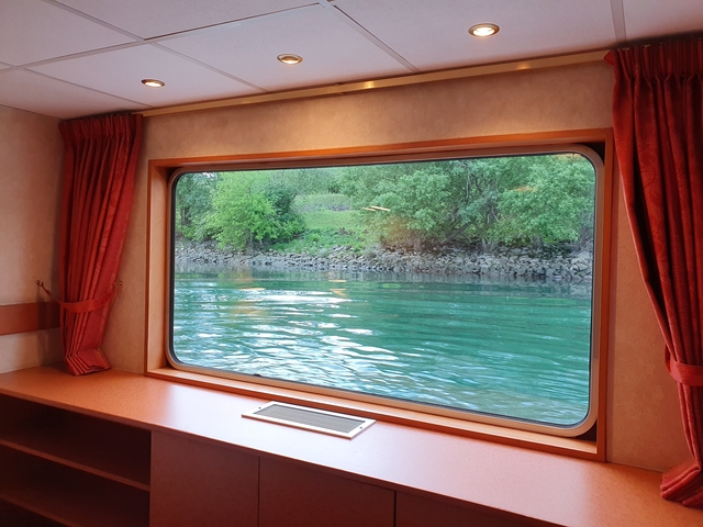 View of a river and trees from a boat window.