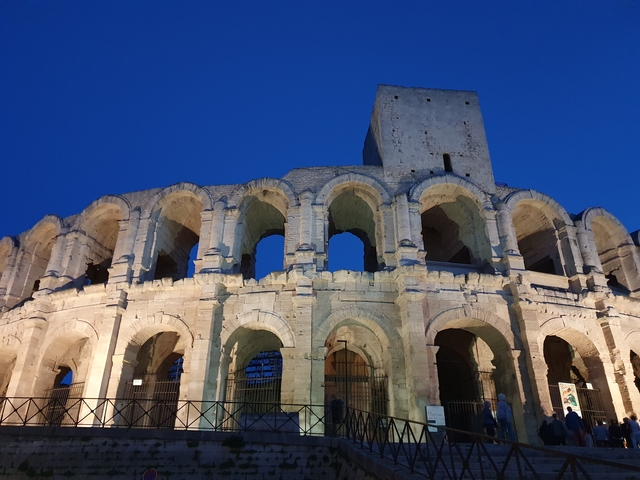Roman amphitheater illuminated at night.