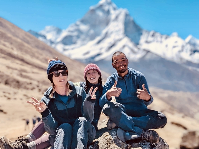 Group of hikers posing with snow-capped mountains.