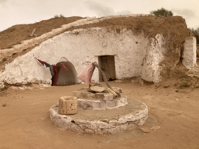 Courtyard with earthen structures and drying clothes.