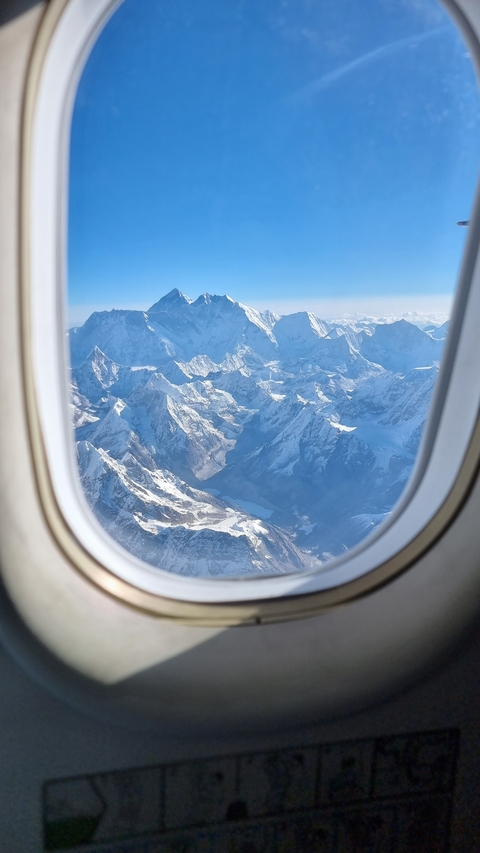 Snowy mountain peaks viewed from an airplane window.