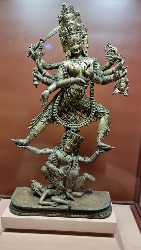       Bronze statue of a deity in a dynamic pose.
  